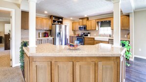 Une cuisine spacieuse avec des meubles en bois, un îlot central et des appareils électroménagers intégrés.