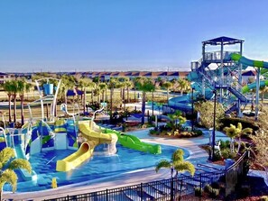 A water park with multiple slides and a pool area, surrounded by palm trees and a clear sky. - Beautiful 5 Bed Villa With Game Room And Pool 5 Bedroom Home by RedAwning (Kissimmee)
