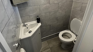 Un bagno con un lavandino bianco, un water e uno specchio.