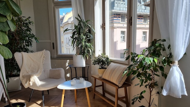 A cozy living room with a sofa, a small round table, and potted plants. - King Paul Suites Down Town Budapest in the heart of the city (Budapest, V. kerület)