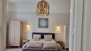 A bedroom with a large bed, two bedside tables, a wardrobe, and a hanging light fixture. - King Paul Suites Down Town Budapest in the heart of the city (Budapest, V. kerület)