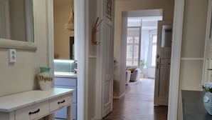 A hallway with a wooden floor, white walls, and a door leading to another room. - King Paul Suites Down Town Budapest in the heart of the city (Budapest, V. kerület)