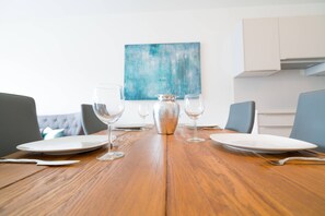 A dining table set with plates, glasses, and cutlery, with a vase in the center.