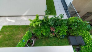 A rooftop garden with a small seating area, a potted plant, and a white wall. - Vienna Residence, Pramergasse - Inner City #6325 (Vienna)
