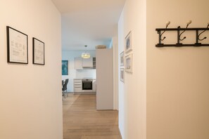 Stylish hallway leads to a fully equipped kitchen with oven and ample storage.