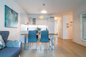 Relax in this stylish living room with a sofa, dining table, and kitchen area.
