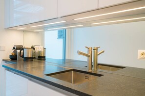 Una cocina moderna con electrodomésticos de acero inoxidable, un lavamanos doble y una encimera elegante.