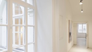 A bright, white hallway with a large arched window and a hanging light fixture. - Vienna Residence, Wasagasse - Alsergrund #6294 (Vienna)