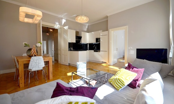 A modern apartment with a dining area, kitchen, and living room.