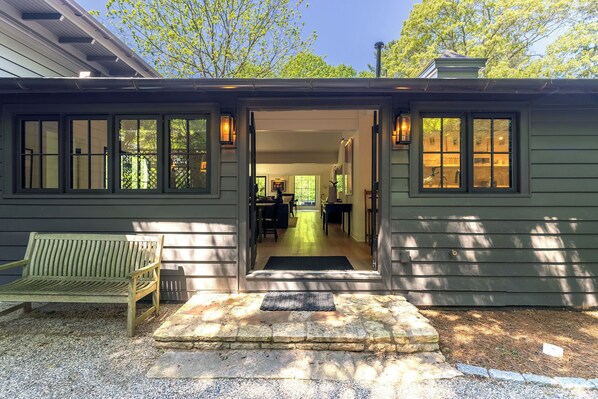 A house with a front porch, a bench, and a door leading to an interior space. - Secluded 3-Bedroom Luxury Retreat near Beach – Perfect Getaway! (Douglas)
