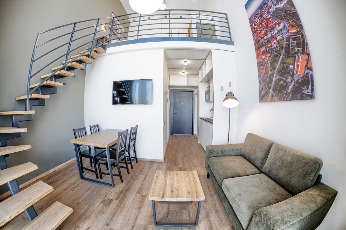 Ein modernes Interieur mit einer Wendeltreppe, einem Essbereich, einer Couch und einer Stadtkulissen-Wandmalerei.