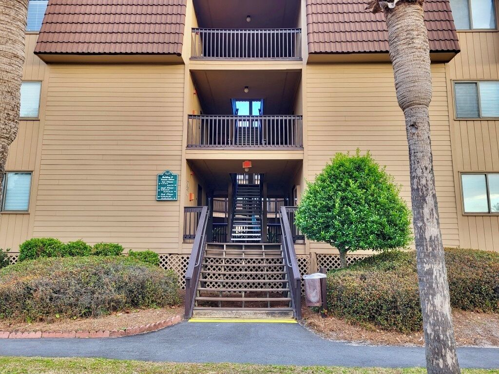 Un edificio de varios pisos con una escalera central que conduce a un balcón.
