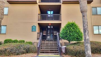 Un edificio de varios pisos con una escalera central que conduce a un balcón.