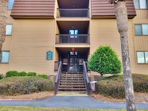 Ein mehrgeschossiges Gebäude mit einer zentralen Treppe, die zu einem Balkon führt.