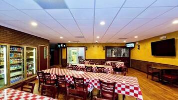 Un restaurante con manteles a cuadros, sillas de madera y una pared de ladrillo.