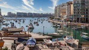 A marina with numerous boats docked, surrounded by residential buildings and a clear sky. - 2BR + Big BBQ Terrace | Heart of St Julian`s (St. Julian`s)