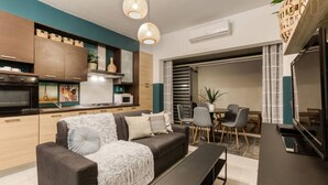A modern living room with a sofa, coffee table, and dining area. - 2BR + Big BBQ Terrace | Heart of St Julian`s (St. Julian`s)