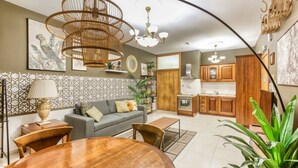 A modern living room with a sofa, dining table, and kitchen area. - Stylish & Cosy 1BR APT in the Heart of Paceville (St. Julian`s)