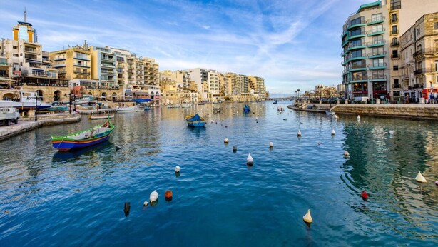 A canal with boats and swans, surrounded by multi-story buildings with balconies. - Stylish & Cosy 1BR APT in the Heart of Paceville (St. Julian`s)