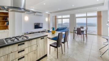 Una cucina moderna con isola centrale, zona pranzo con sedie e un'ampia finestra vista.