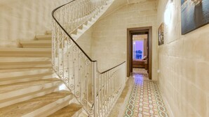 A staircase with ornate metal railings and patterned floor tiles.