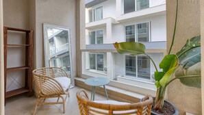 A balcony with wicker chairs, a small table, and a potted plant. - Designer 3BR home with Private Balcony in Gzira (Il-Gżira)