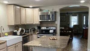 A kitchen with light wood cabinets, a stainless steel microwave, a stove, and a granite countertop. - Leaping Waters - peaceful home located along the West Canada in Barneveld, NY.   (Barneveld)