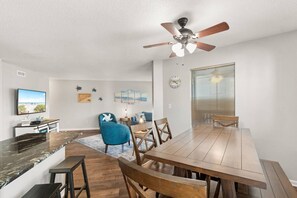 A dining area with a wooden table, chairs, and a ceiling fan. - Golf Views - Outdoor pool, 3 Beds, 1 mile 2 Beach (North Myrtle Beach)