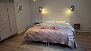 A neatly arranged bedroom with a bed, bedside tables, a wardrobe, and a hanging light fixture. - Gîte Le Colombage, 2 bedrooms, free parking, 25 km from Strasbourg (Scharrachbergheim)