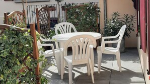A patio area with a table and chairs, surrounded by potted plants and a wooden trellis. - Gîte Le Colombage, 2 bedrooms, free parking, 25 km from Strasbourg (Scharrachbergheim)