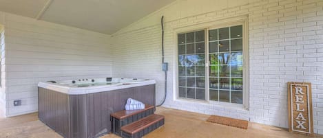 Un espace bien-être avec un jacuzzi, des marches en bois et un panneau indiquant « RELAX ».