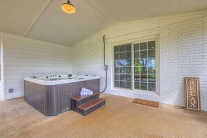 A spa area with a hot tub, wooden steps, and a 'RELAX' sign.