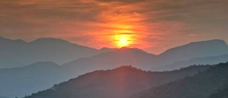 A sunset over a mountain range with a clear sky.