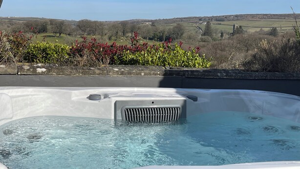 A hot tub with a clear view of a rural landscape in the background.