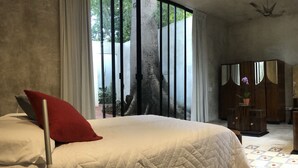 Un dormitorio con una cama grande, un armario de madera y un escritorio con una silla.