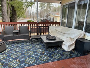 Un espace extérieur aménagé avec des meubles en osier, un tapis à motifs et une table couverte.