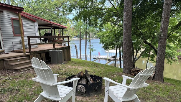 Una terrazza sul lago con poltrone Adirondack e un braciere.