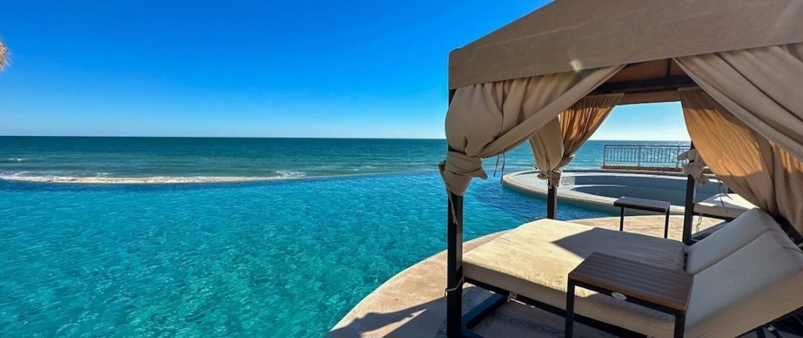 A beachside cabana with a pool overlooking the ocean.