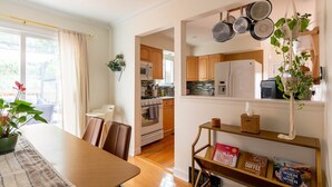 A modern kitchen with wooden cabinets, a built-in oven, and a hanging pot rack.