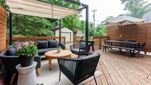 A wooden deck with outdoor furniture, including a sofa, chairs, and a table.