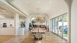 Un'ampia cucina con una grande isola, elettrodomestici moderni e un lampadario.
