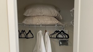An open closet with a hanging rack, two white robes, and a beige pillow on top. - Pacific University Stay,  very close to the University and downtown Forest Grove (Forest Grove)