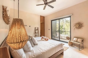 A modern bedroom with a bed, a ceiling fan, a large window, and a balcony.