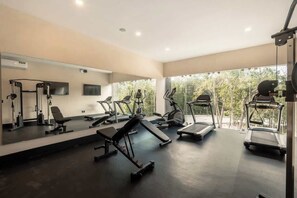 A gym with treadmills, elliptical machines, and weight benches. - Balam Bohemian Paradise Beach Club + Private Pool (Tulum)