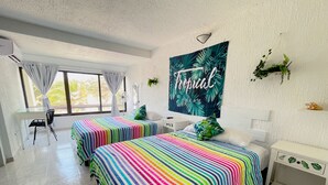 A hotel room with two beds, a desk, a chair, and a large window with curtains. - Seaside Escape renovated Studio at turquoise Cancun beach  (Cancún)