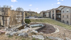 Zona residencial con edificios de piedra identificada como StoneBridge The Fairways Condos Villas.