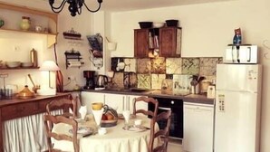 A compact kitchen with a dining table, chairs, and a refrigerator. - The Marquis refuge: Pleasant T3 with terrace (Marsanne)