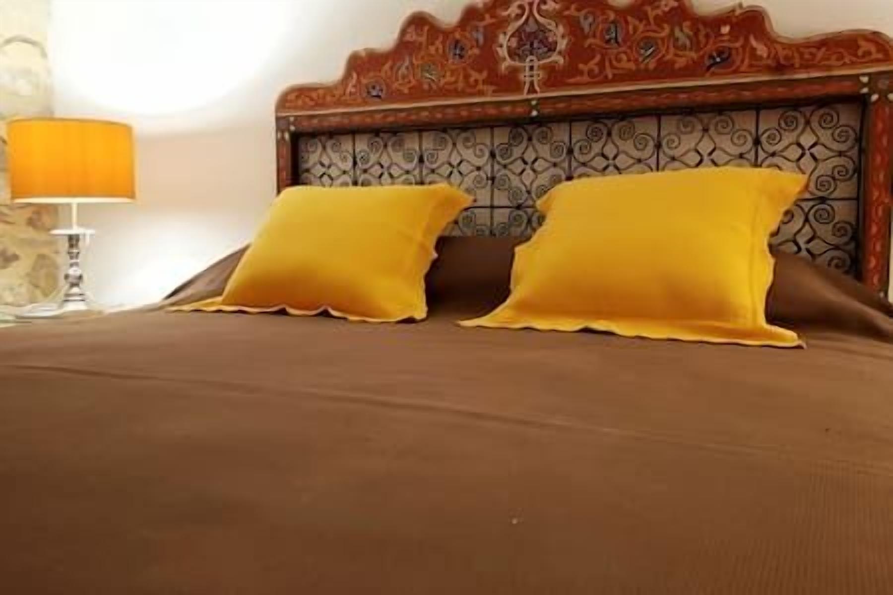 Ein Bett mit zwei Kissen und einem Kopfteil mit dekorativem Muster.
