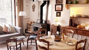 A cozy living room with a fireplace, a dining table set with plates and glasses, and a sofa with cushions. - The Marquis refuge: Pleasant T3 with terrace (Marsanne)