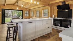 Een moderne keuken met een groot schiereiland, barkrukken en inbouwovens.